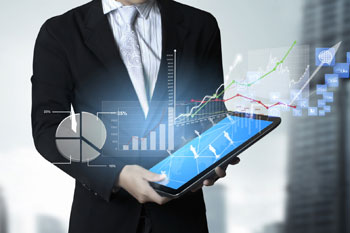 Wirtschaftsinformatiker schaut sich verschiedene Infografiken auf einem Tablet an