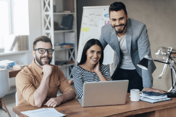 Eine Gruppe junger Leute an einem Schreibtisch.