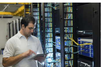 Mann arbeitet an einem Großrechner