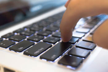 Hand tippt auf Tastatur