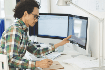 Mann vor zwei Bildschirmen